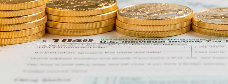 Solid gold coins on 2014 form 1040 Stock photo © backyardproductions
