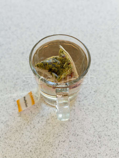 Stock photo: Chamomile teabag in glass mug on table
