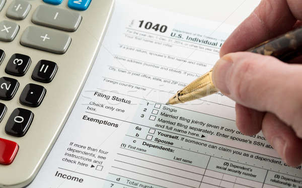 Pen and calculator on 2014 form 1040 Stock photo © backyardproductions
