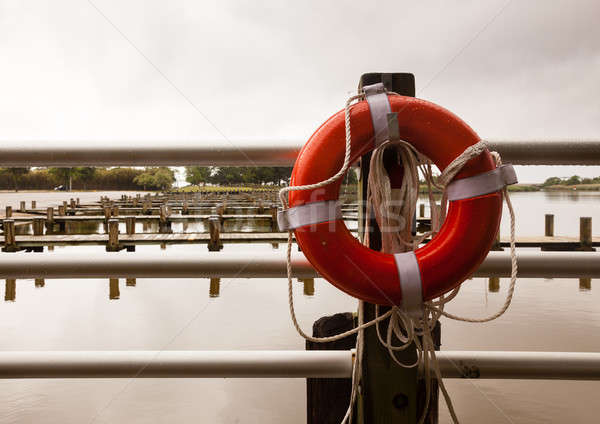Red life belt in front of empty boat dock harbor Stock photo © backyardproductions