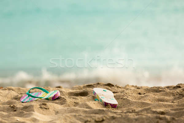 Discarded flipflops on sandy beach by ocean Stock photo © backyardproductions