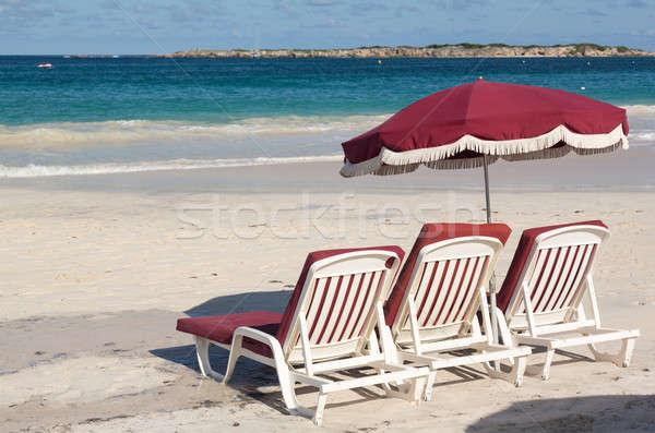 Three beach loungers and umbrella on sand Stock photo © backyardproductions