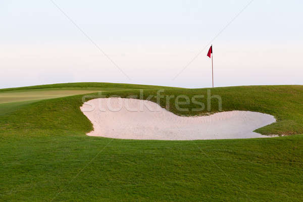 Sand bunker in front of golf green and flag Stock photo © backyardproductions