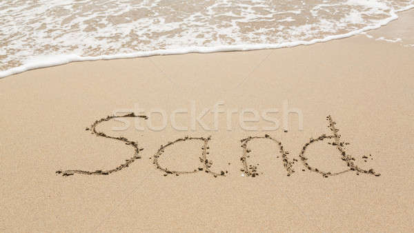 Drawing in beach by ocean of Sand word Stock photo © backyardproductions