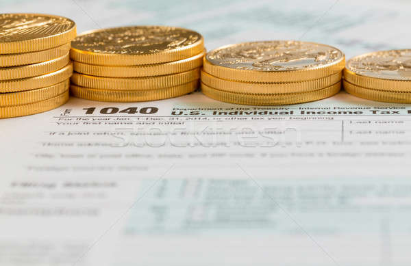 Stock photo: Solid gold coins on 2014 form 1040