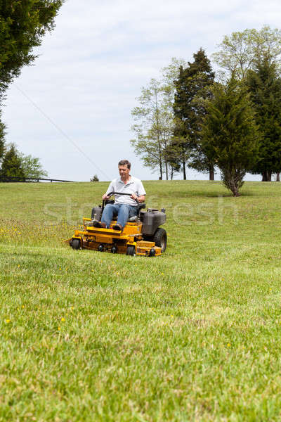 Senior man on zero turn lawn mower on turf Stock photo © backyardproductions