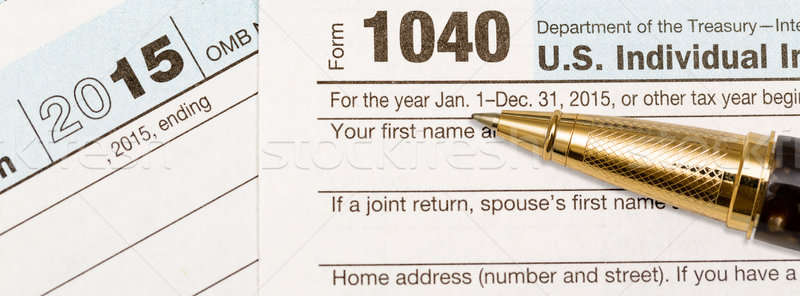 Gold pen laying on 2015 IRS form 1040 Stock photo © backyardproductions