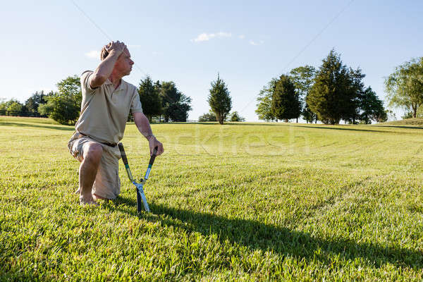 Senior man cutting grass with shears Stock photo © backyardproductions