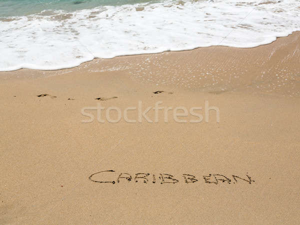 Caribbean written in sand with sea surf Stock photo © backyardproductions