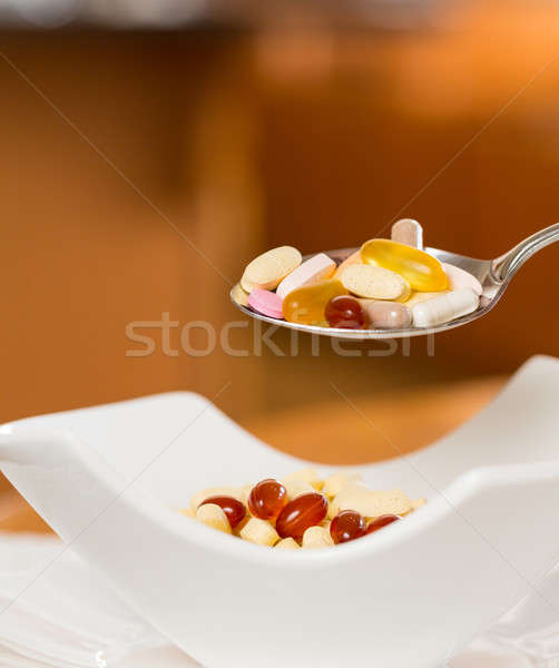 Spoon of vitamins over bowl of tablets Stock photo © backyardproductions