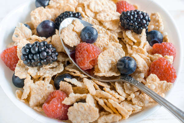 Corn flakes and berry fruits Stock photo © badmanproduction