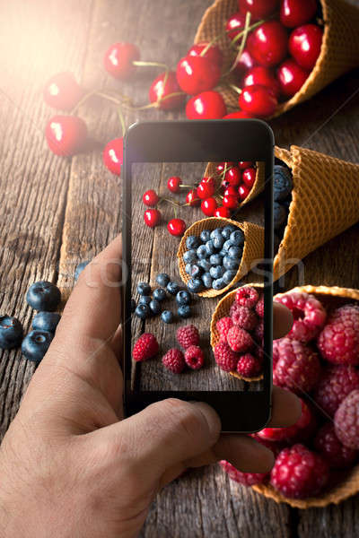 Férfi fényképezés gyümölcsök fagylalttölcsér mobiltelefon üzlet Stock fotó © badmanproduction
