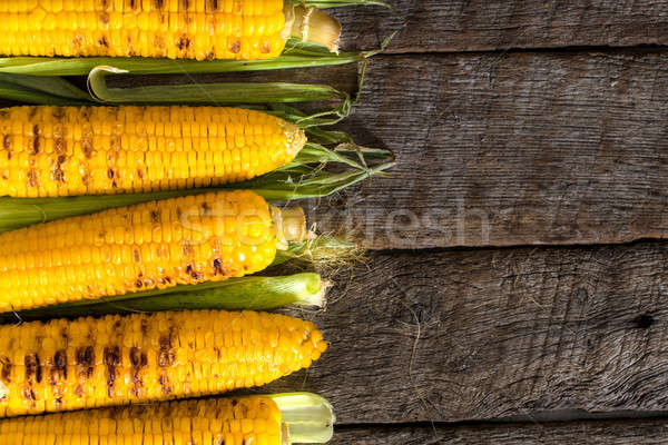 Grilled corn on wooden table Stock photo © badmanproduction