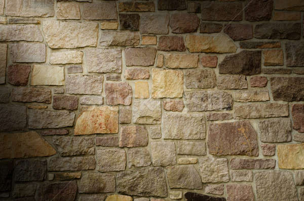 Stock photo: Masonry Wall of Multicolored Stone Lit Diagonally