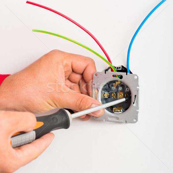Screwing Electrical Wall socket Stock photo © barabasa