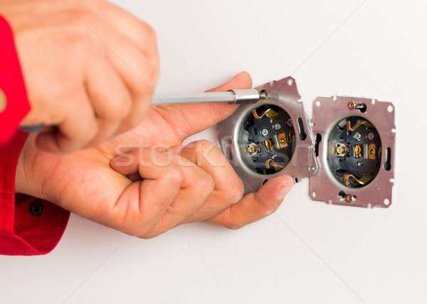 Screwing Socket Shell On Wall Stock photo © barabasa