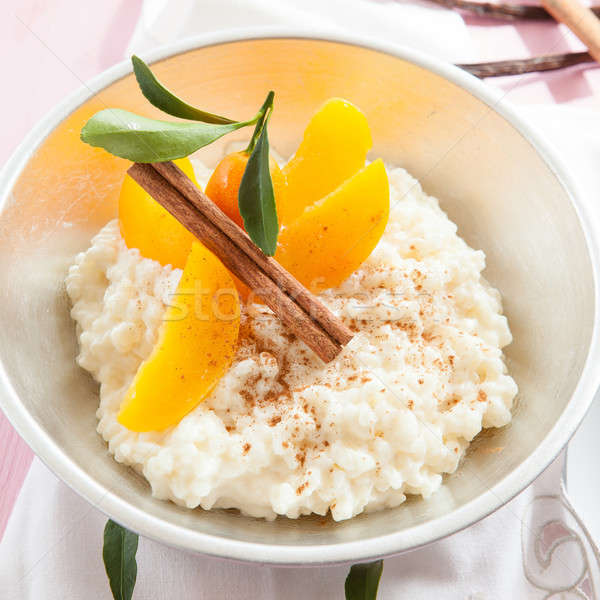 Budinca de orez piersici castron lapte ceaşcă desert Imagine de stoc © BarbaraNeveu