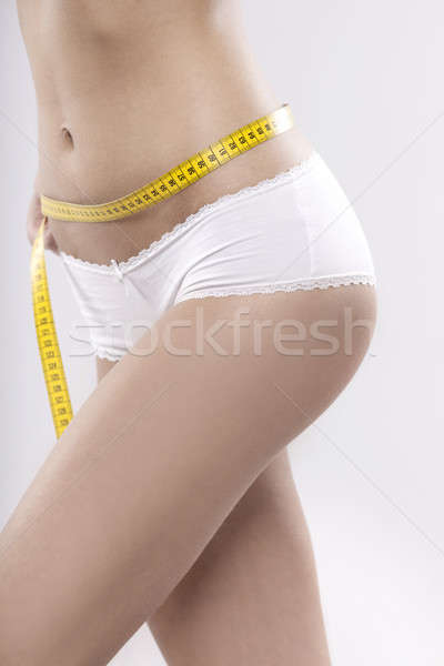 Beautiful sporty woman with yellow measure around body  Stock photo © bartekwardziak