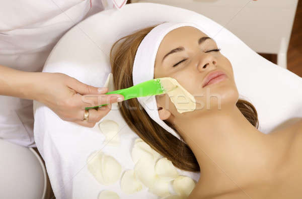 young woman getting beauty skin mask treatment on her face with  Stock photo © bartekwardziak