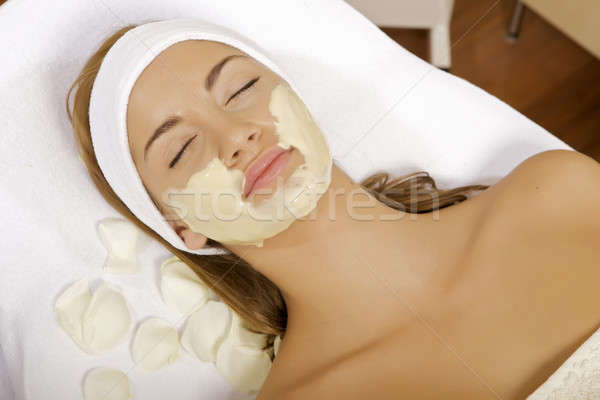 Stock photo: young woman getting beauty skin mask treatment on her face with 