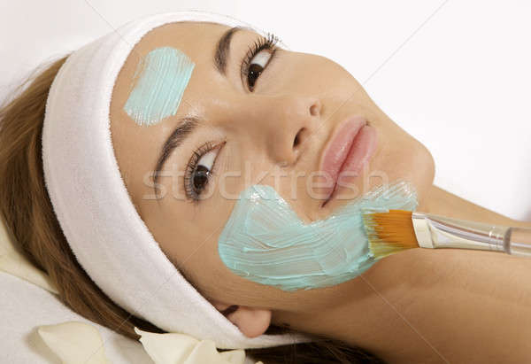 Stock photo: young woman getting beauty skin mask treatment on her face with 