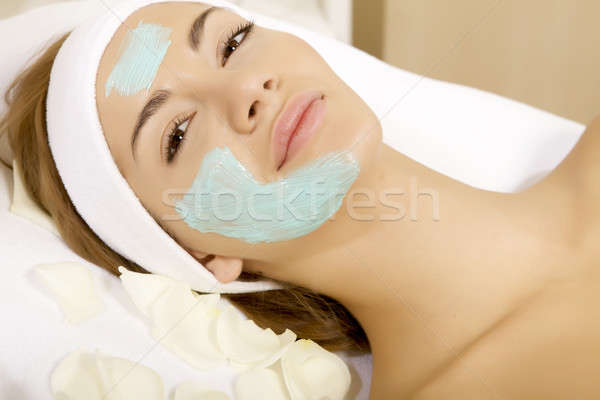 young woman getting beauty skin mask treatment on her face with  Stock photo © bartekwardziak