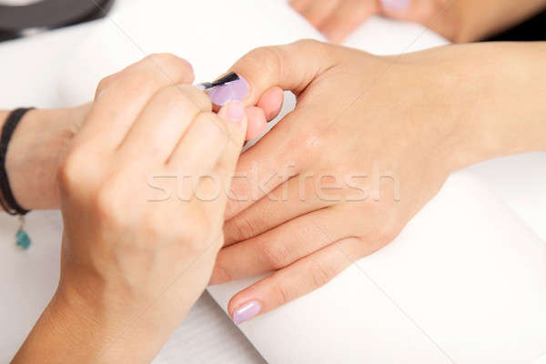 Manicure - Beautiful manicured woman's nails with violet nail po Stock photo © bartekwardziak