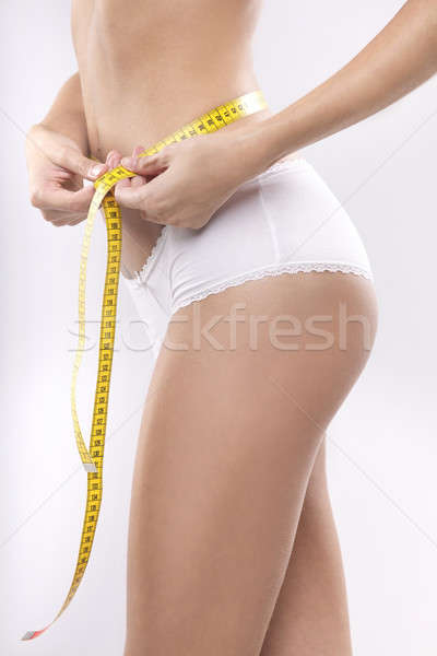 Stock photo: Beautiful sporty woman with yellow measure around body 