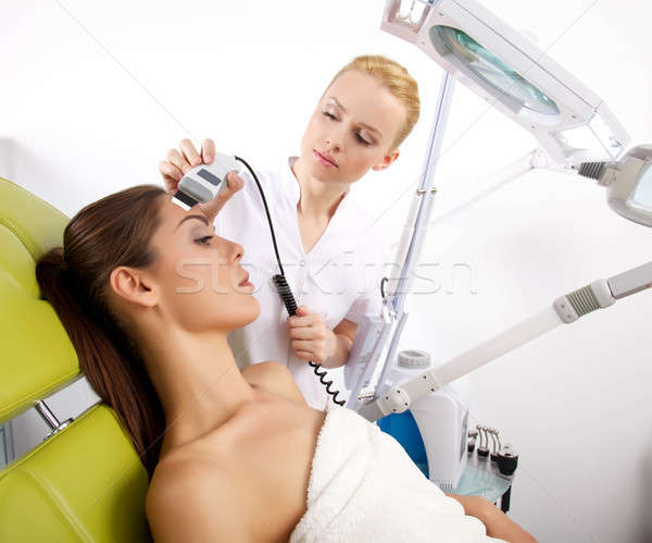woman having a stimulating facial treatment from a therapist Stock photo © bartekwardziak