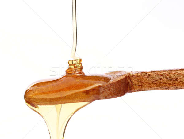 Dripping honey on wooden spoon Stock photo © bdspn