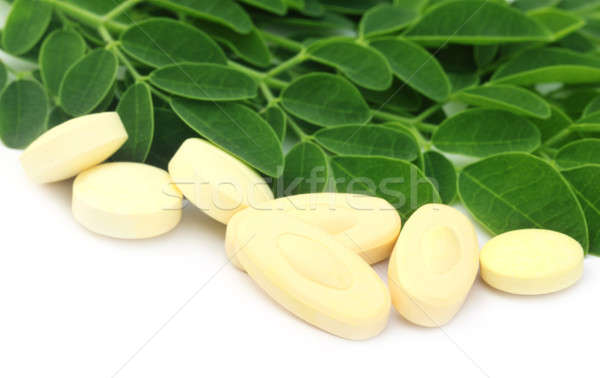 Edible moringa leaves with pills Stock photo © bdspn