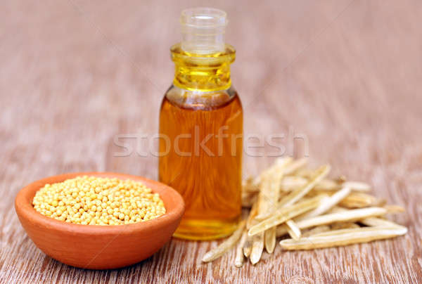 Golden Mustard with empty pods and oil in a bottle Stock photo © bdspn