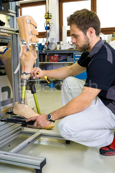 Man working on prosthetic leg assembly Stock photo © belahoche