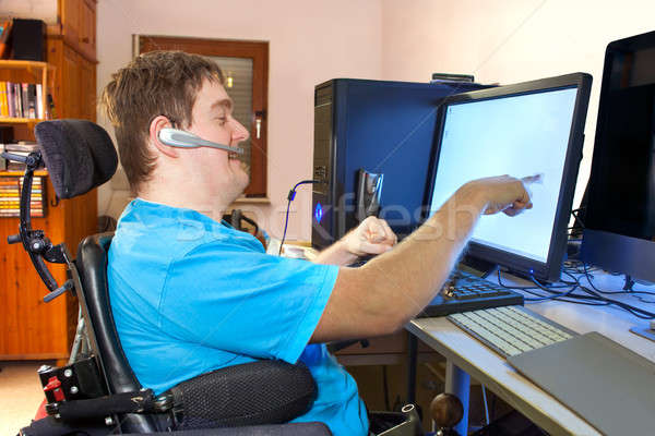 Man with infantile cerebral palsy using a computer Stock photo © belahoche