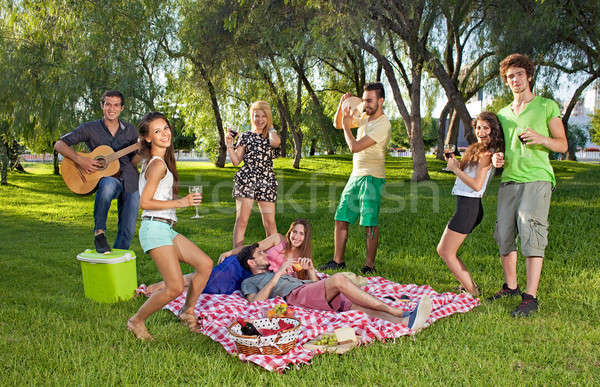 Happy teenage friends enjoying a picnic outdoors Stock photo © belahoche