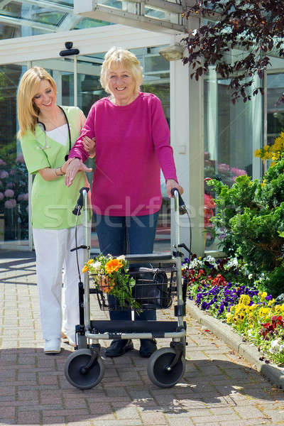 Nurse Helping Senior Woman to Walk with Walker Stock photo © belahoche