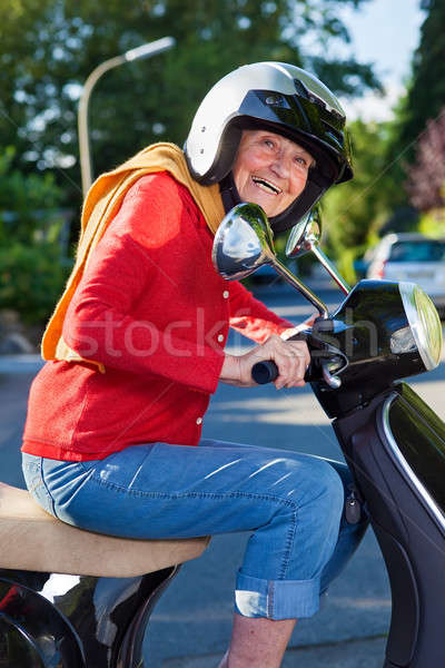 Laughing active senior woman on a scooter Stock photo © belahoche