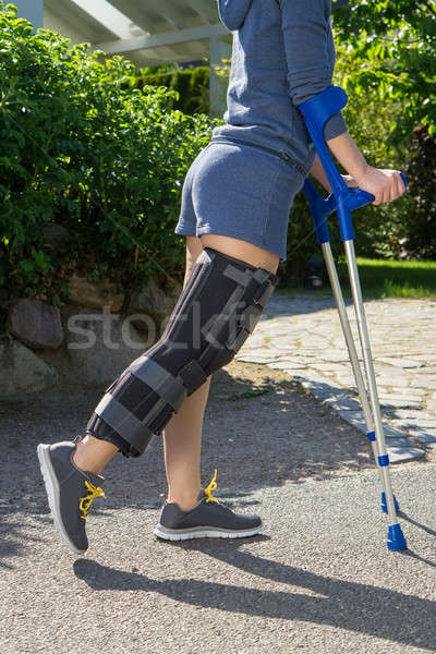 Young woman wearing a leg brace, side view Stock photo © belahoche