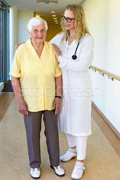 Nurse Assisting a Senior Woman Walking at Corridor Stock photo © belahoche