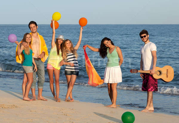 Group of young people enjoying beach party with guitar and ballo Stock photo © belahoche