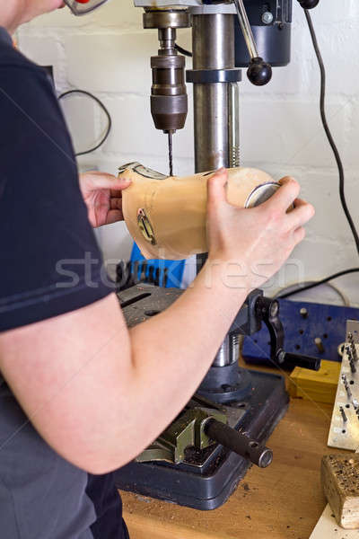 Technician drilling hole into prosthetic limb Stock photo © belahoche
