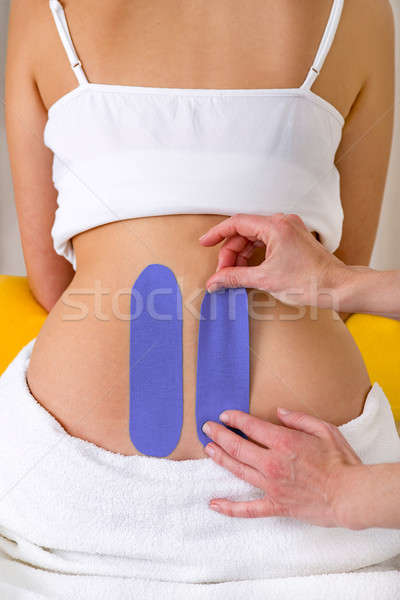 Chiropractor applying two kinesiology tapes. Stock photo © belahoche