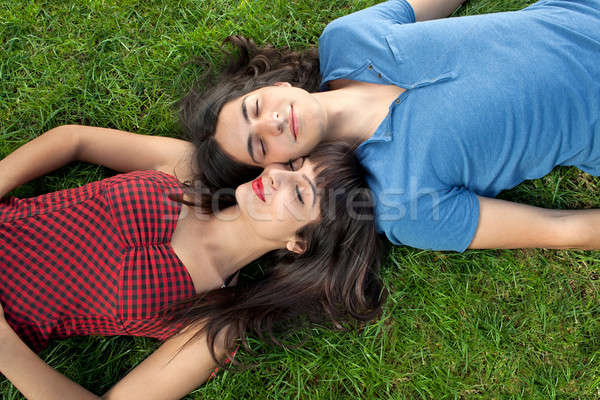 Young couple taking a nap on green grass Stock photo © belahoche