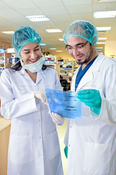 Lab technicians smiling as they study the results.  Stock photo © belahoche