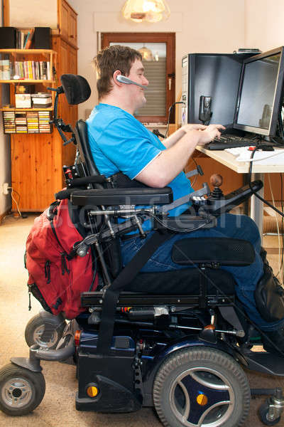 Man with infantile cerebral palsy using a computer Stock photo © belahoche