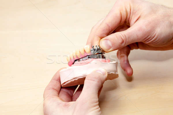Tonen menselijke tandheelkundige prothese geïsoleerd houten tafel Stockfoto © belahoche