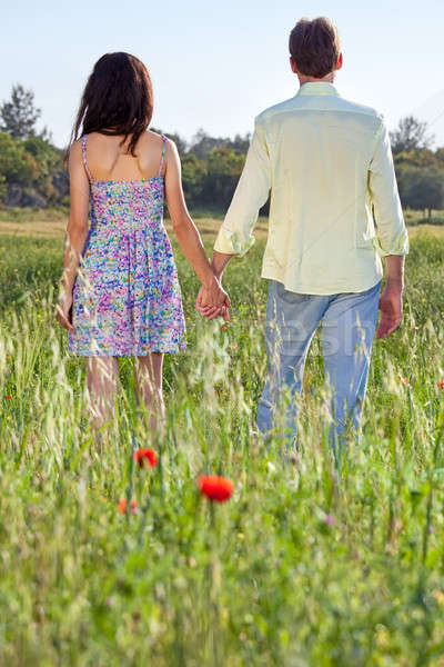 Young couple walking through a poppy field Stock photo © belahoche