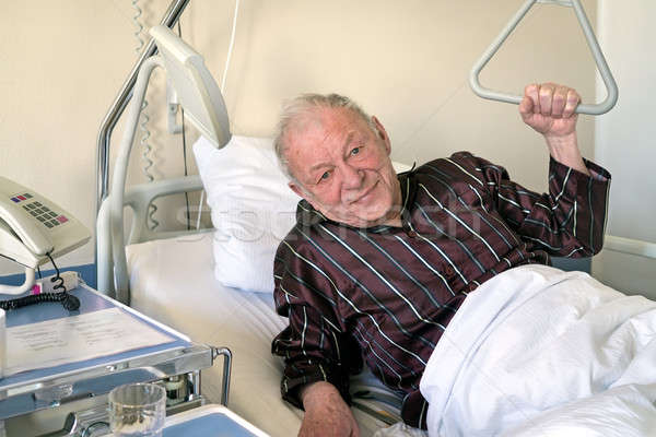 Senior Mann Krankenhausbett up ein Ellenbogen Stock foto © belahoche