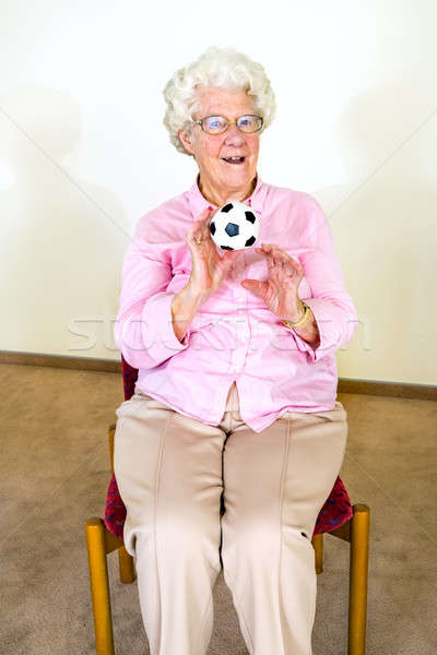Happy elderly woman catching a ball Stock photo © belahoche