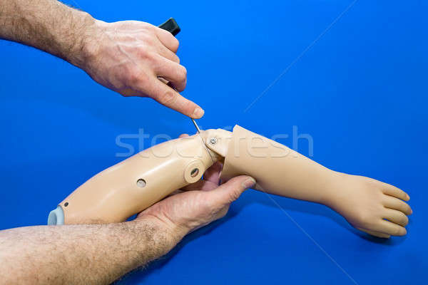 Technician adjusting elbow on artificial arm Stock photo © belahoche